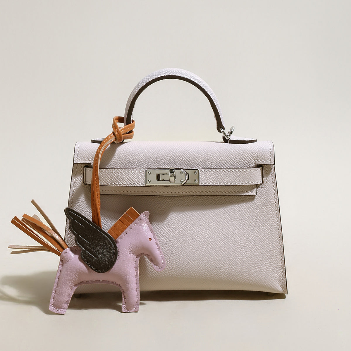 trendy petite top handle bag with a horse charm pink 1
